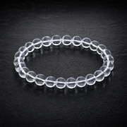 Clear quartz 8mm bracelet on a charcoal stone surface