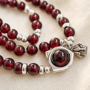 Macro detail of garnet beads and the lotus heart setting