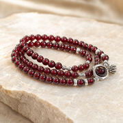 Three-quarter studio view of the garnet lotus heart bracelet