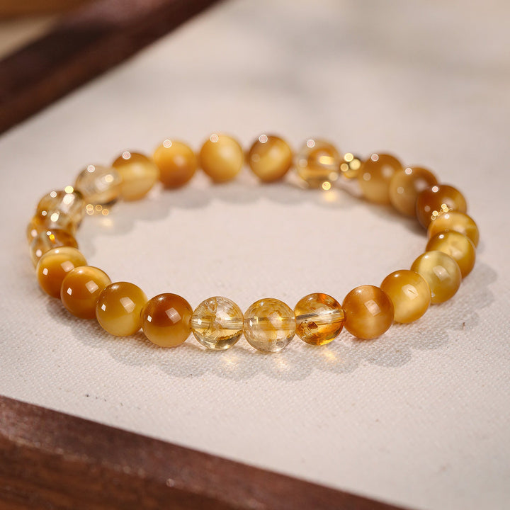 Golden tiger eye and yellow crystal bracelet on warm ivory linen