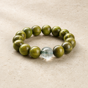 Green sandalwood and green phantom bracelet on warm ivory stone