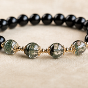 Macro detail of four green phantom focal beads and gold-tone spacers